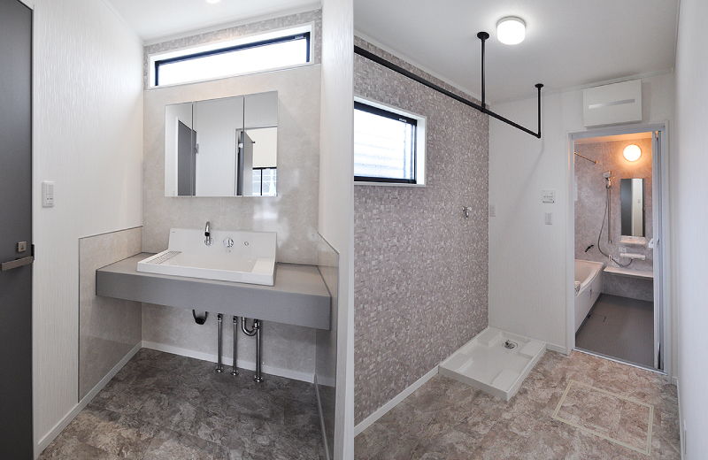 横長の窓から光が入るセパレートの洗面室と脱衣室